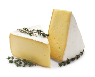 Photo of Pieces of tasty camembert cheese and thyme isolated on white