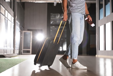 Photo of Man with black travel suitcase in airport