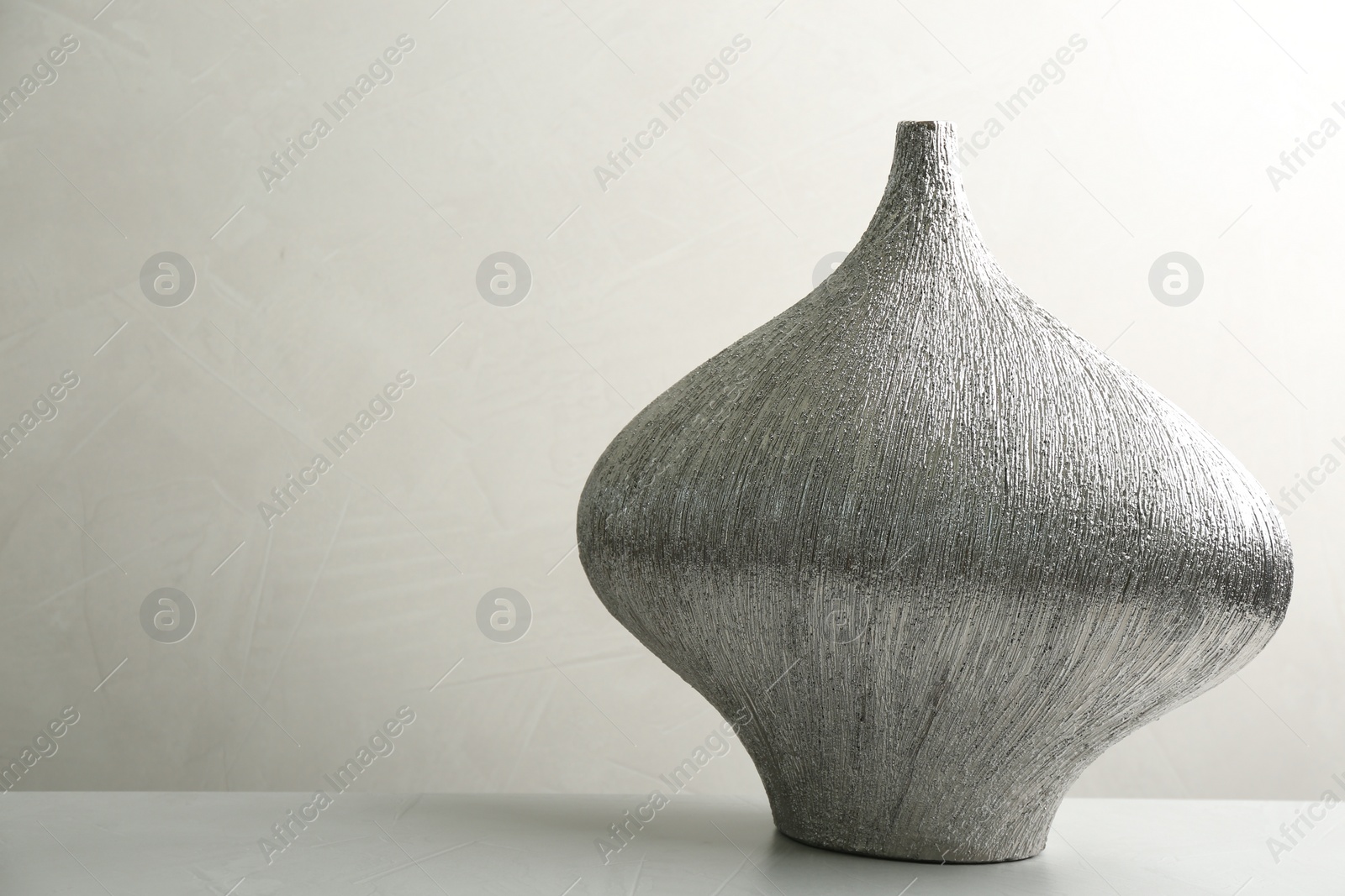 Photo of Stylish ceramic vase on stone table. Space for text