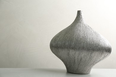 Stylish ceramic vase on stone table. Space for text