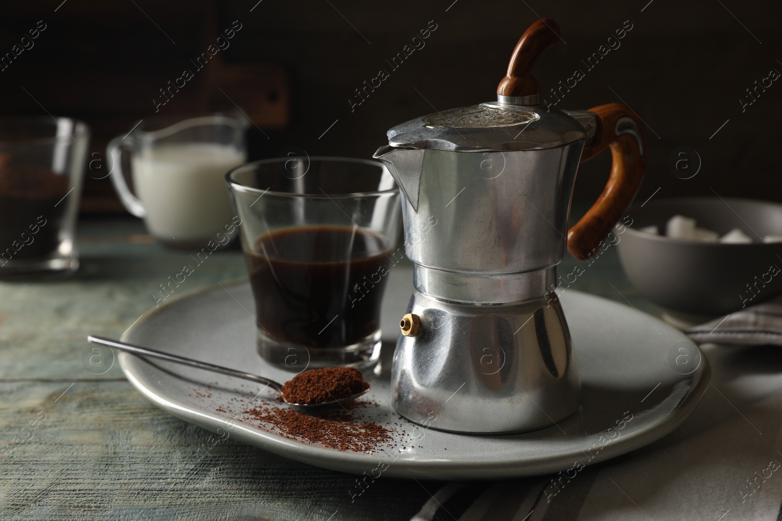 Photo of Brewed coffee in glass and moka pot on rustic wooden table