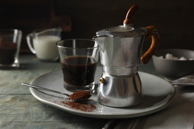 Photo of Brewed coffee in glass and moka pot on rustic wooden table