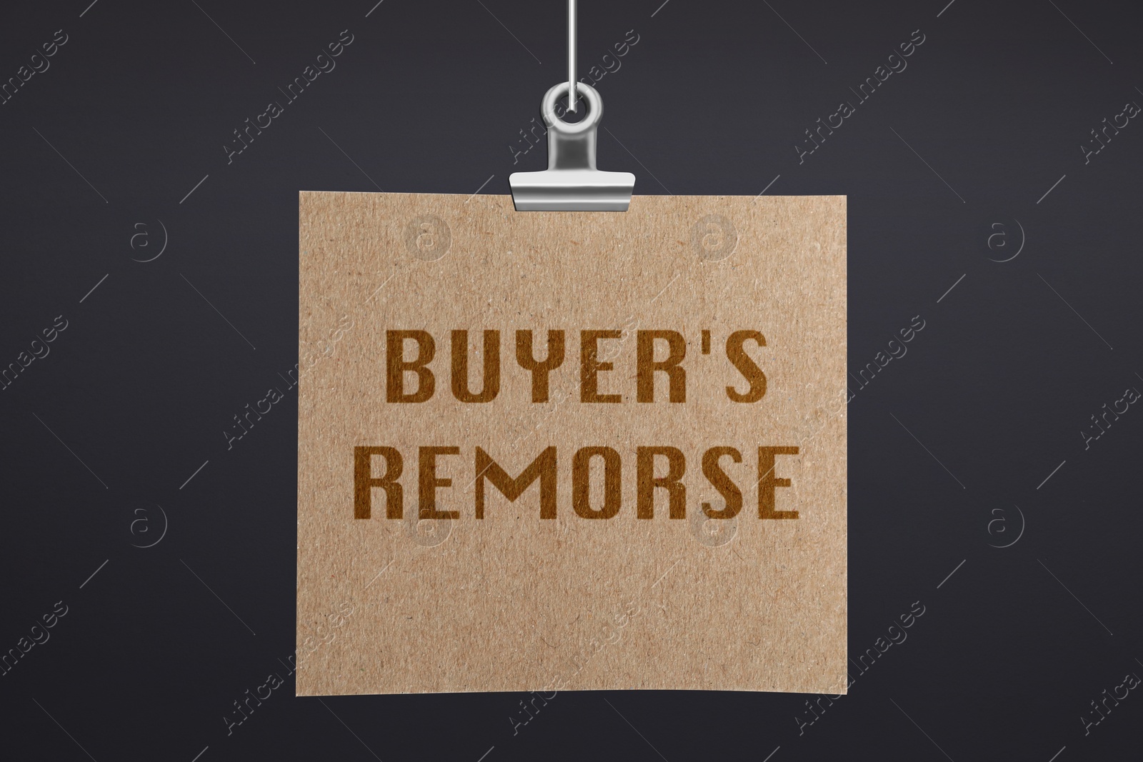 Image of Text Buyer's Remorse on hanging poster against dark grey wall