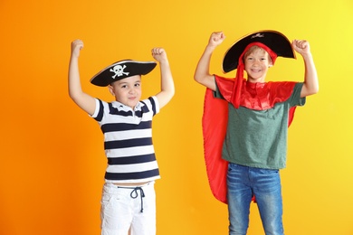 Photo of Adorable little children playing pirates on color background. Indoor recreation