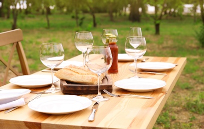 Photo of Set of dishware on table outdoors. Summer picnic