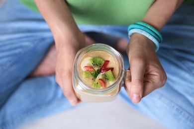 Young woman with mason jar of healthy smoothie, closeup