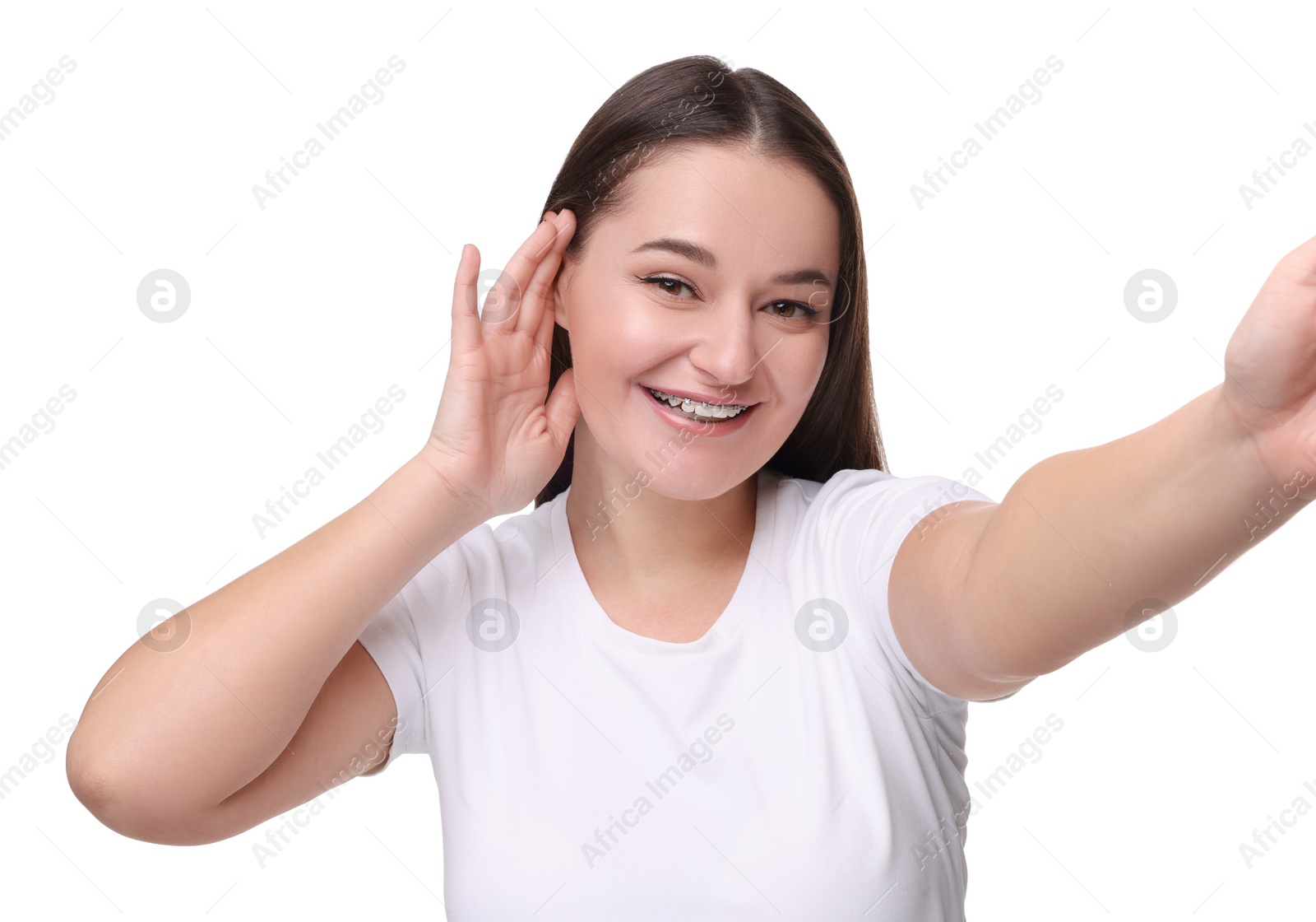 Photo of Smiling woman with dental braces taking selfie on white background