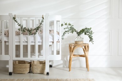 Stylish baby room decorated with eucalyptus branches