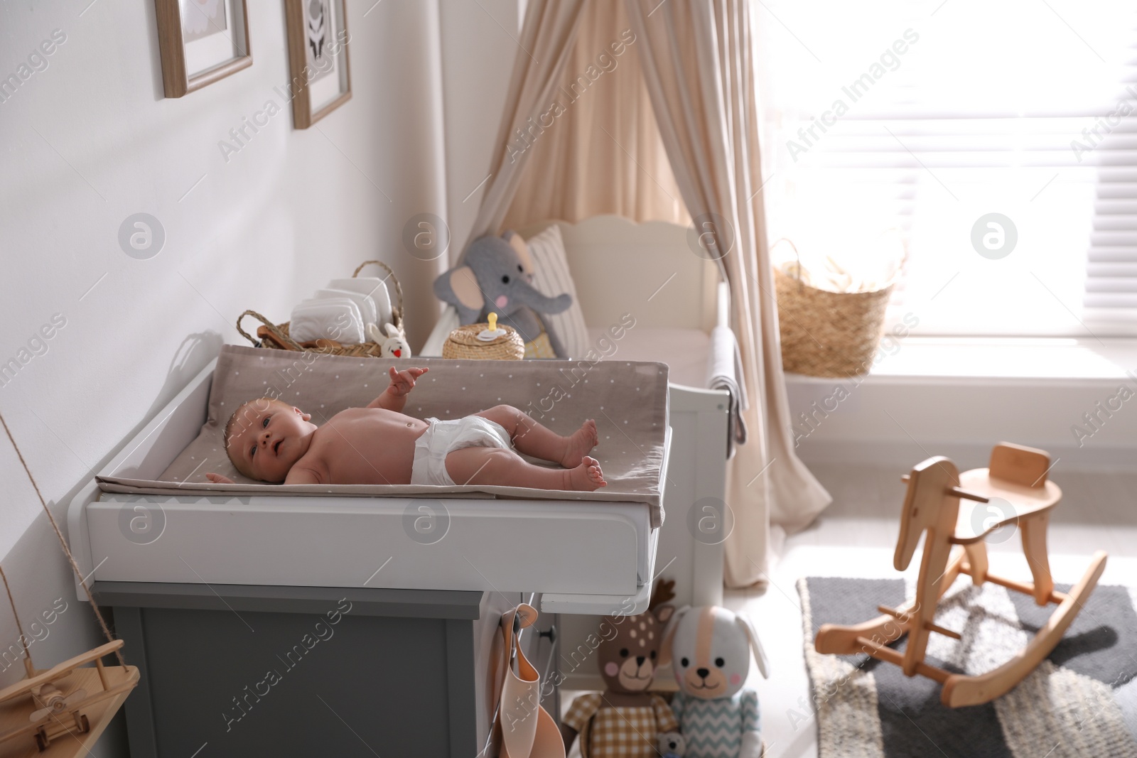 Photo of Cute little baby on changing table in room