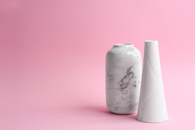 Stylish empty ceramic vases on pink background. Space for text