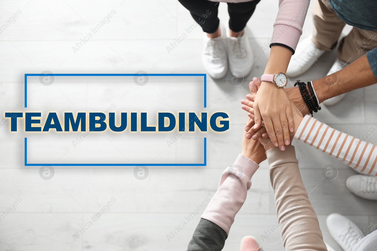 Image of People holding hands together over wooden background, closeup. Teambuilding concept