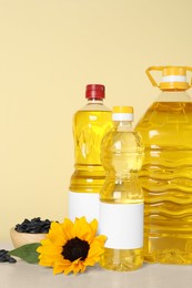Photo of Bottles of cooking oil, sunflower and seeds on white table