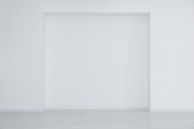Photo of Empty room with niche in white wall during repair