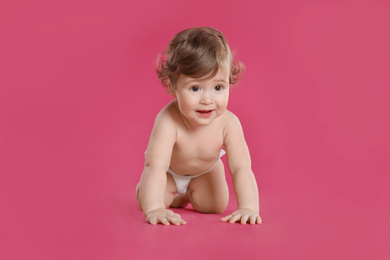 Photo of Cute little baby in diaper on pink background
