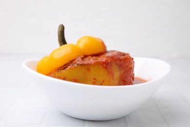 Photo of Delicious stuffed bell peppers on white tiled table