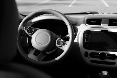 Photo of Black steering wheel and dashboard in modern car