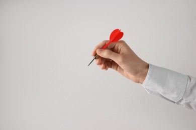 Photo of Businesswoman holding red dart on light background, closeup. Space for text