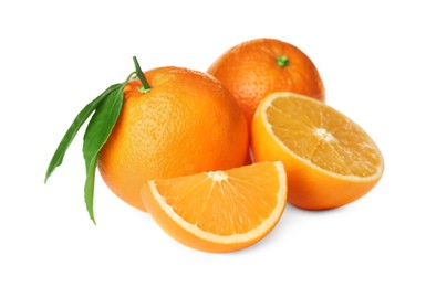 Cut and whole fresh ripe oranges with green leaves on white background