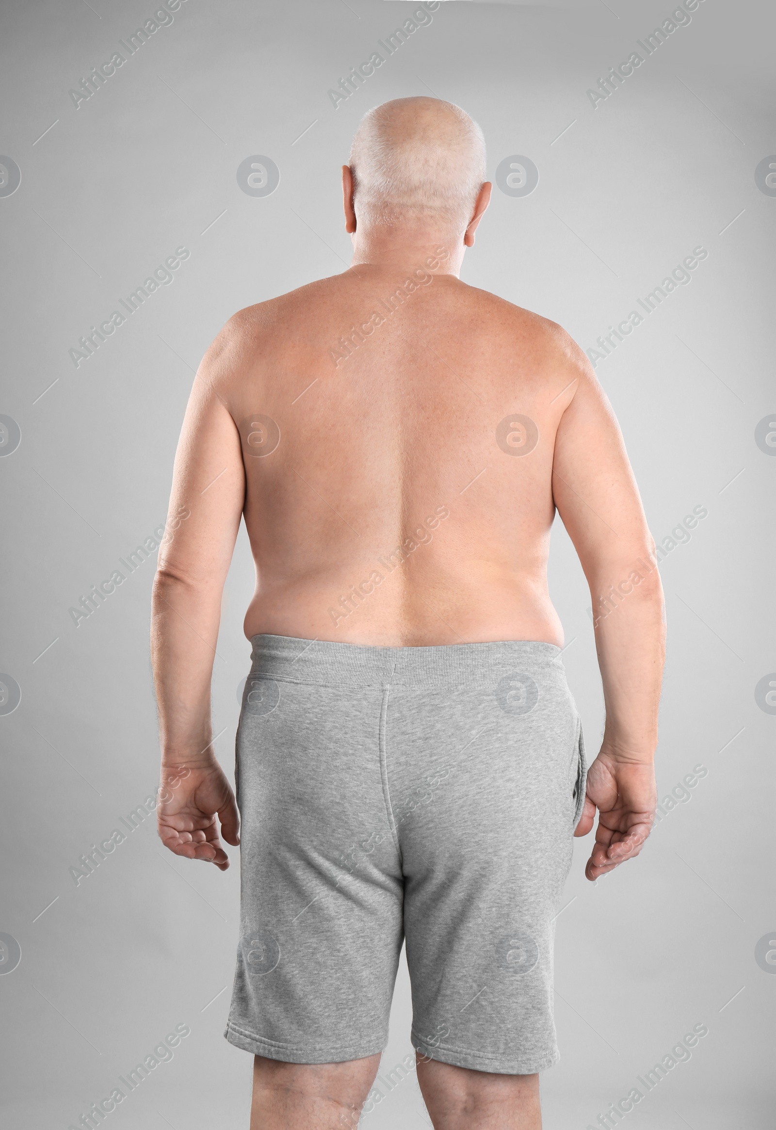 Photo of Fat senior man on grey background. Weight loss
