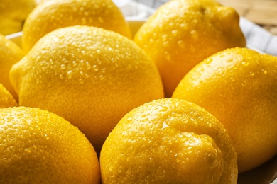 Photo of Ripe whole lemons with water drops, closeup view