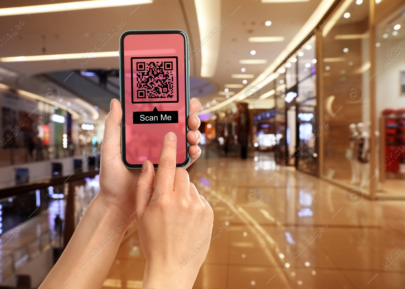 Image of Woman holding smartphone with QR code on screen in shopping mall, closeup