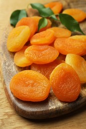 Tasty apricots on wooden table, closeup. Dried fruits