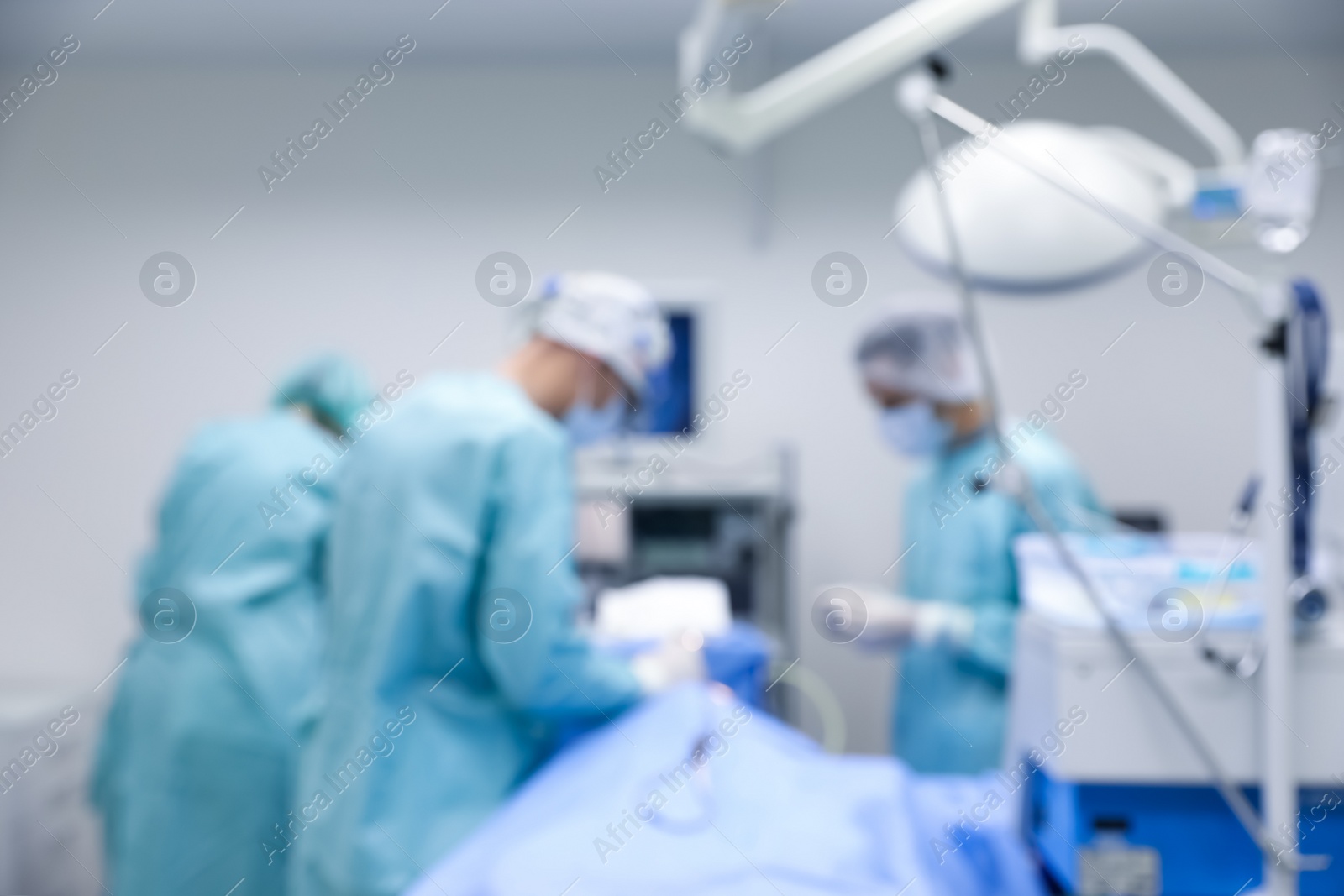 Photo of Blurred view of doctors operating patient in surgery room