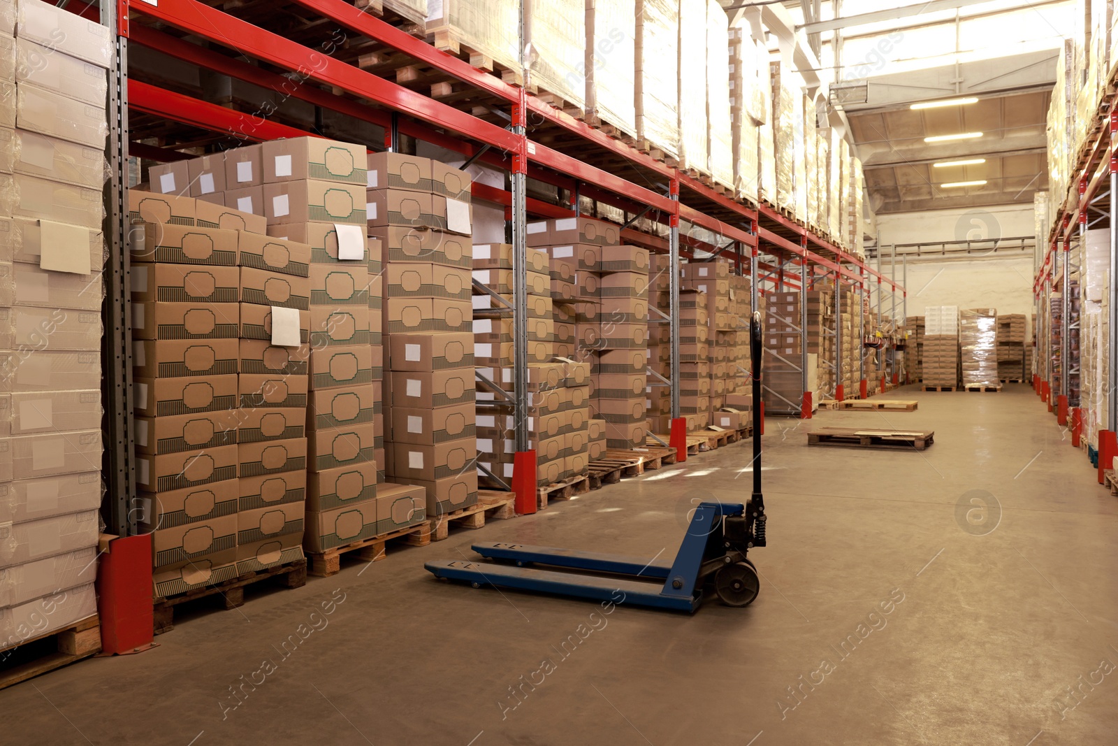 Image of Manual forklift near storage racks in warehouse. Logistics concept