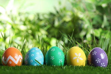 Photo of Colorful Easter eggs in green grass. Space for text