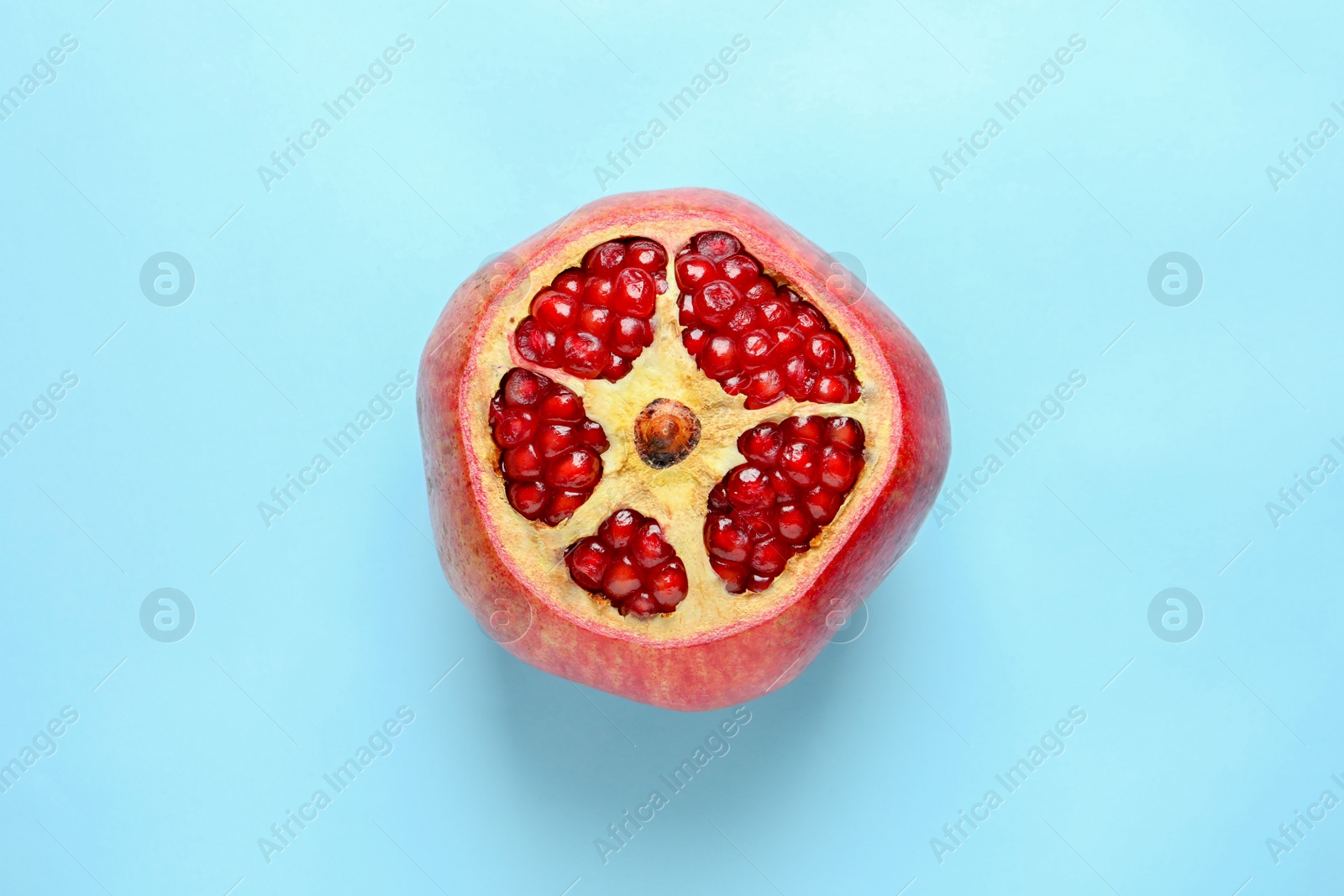 Photo of Ripe red pomegranate fruit with juicy seeds on color background, top view