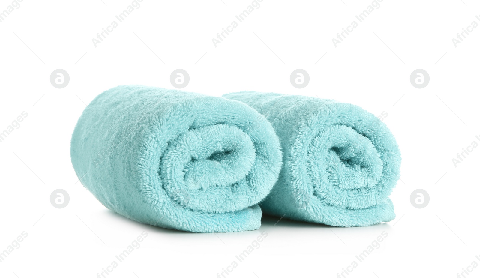 Photo of Rolled clean soft towels on white background