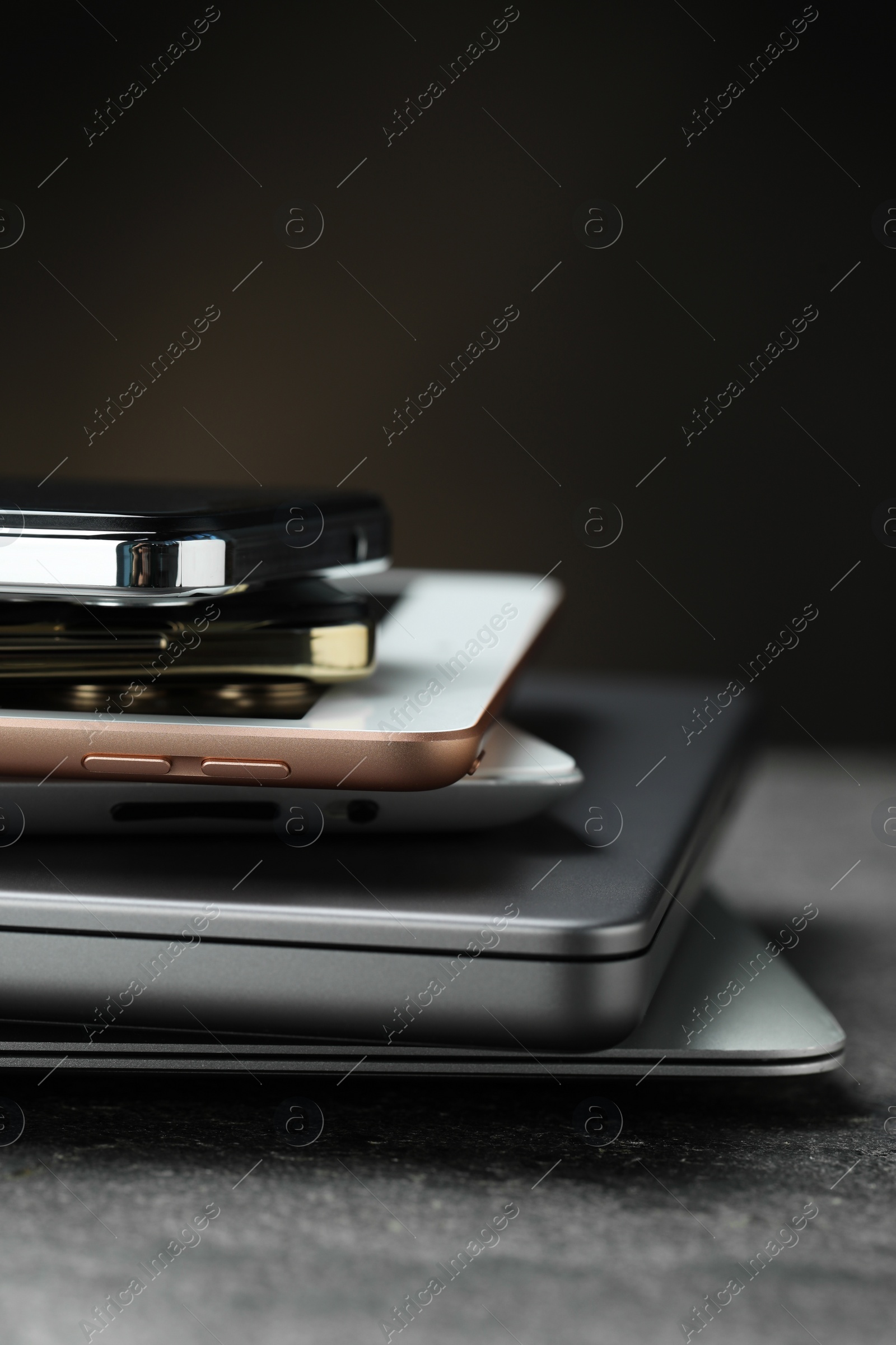 Photo of Stack of electronic devices on grey table, closeup