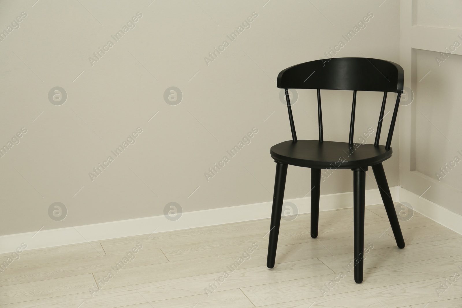 Photo of Black wooden chair near light wall in room. Space for text