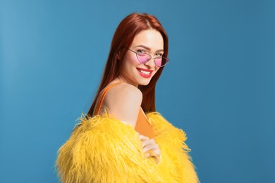 Photo of Stylish woman with red dyed hair on light blue background