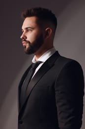 Photo of Handsome bearded man in stylish suit on grey background