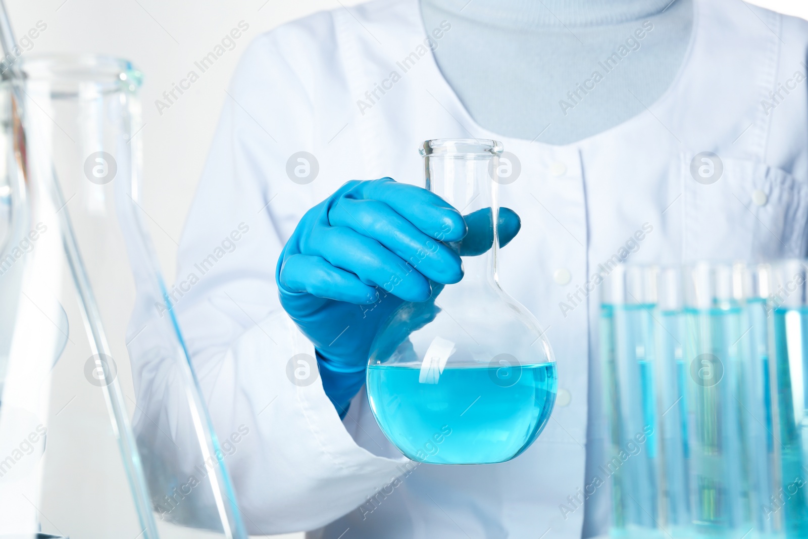 Photo of Scientist holding Florence flask with color liquid, closeup. Solution chemistry