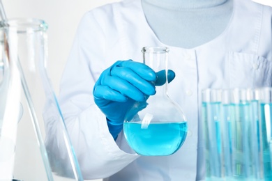 Scientist holding Florence flask with color liquid, closeup. Solution chemistry