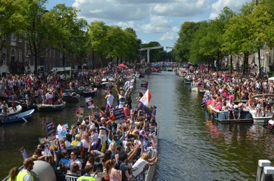 AMSTERDAM, NETHERLANDS - AUGUST 06, 2022: Many people in boats at LGBT pride parade on river