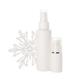 Bottles of hand cream and snowflake isolated on white. Winter skin care