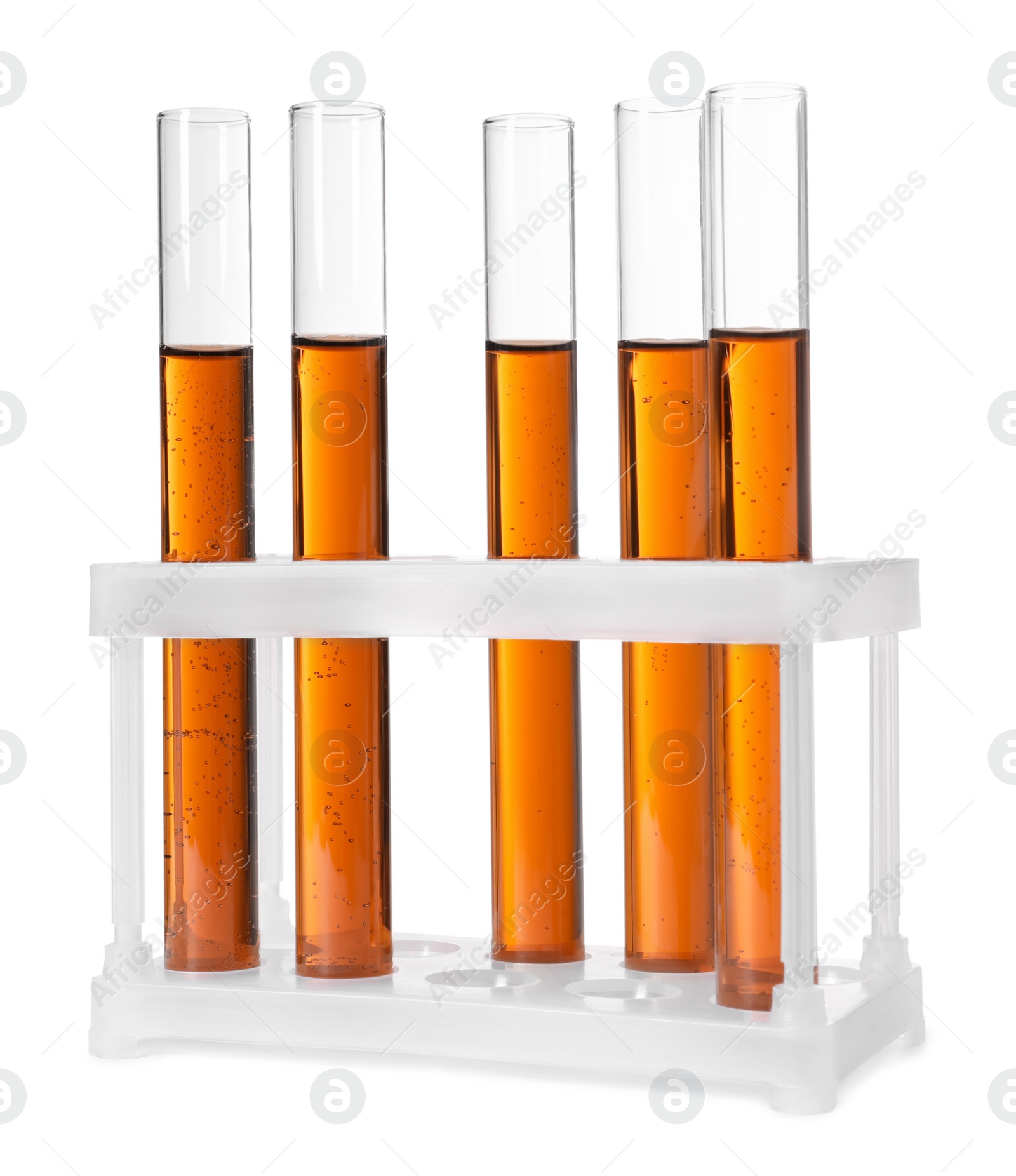 Photo of Test tubes with brown liquid in stand on white background