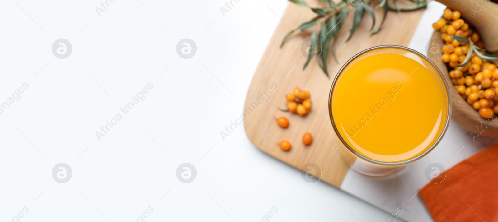 Image of Top view of sea buckthorn juice on white table, space for text. Banner design