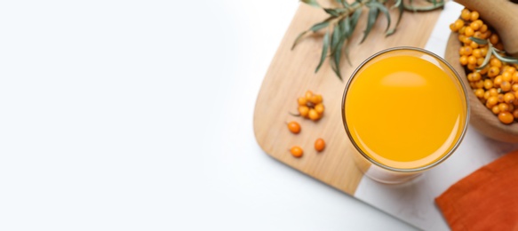 Image of Top view of sea buckthorn juice on white table, space for text. Banner design