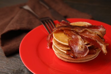 Delicious pancakes with bacon on table, closeup