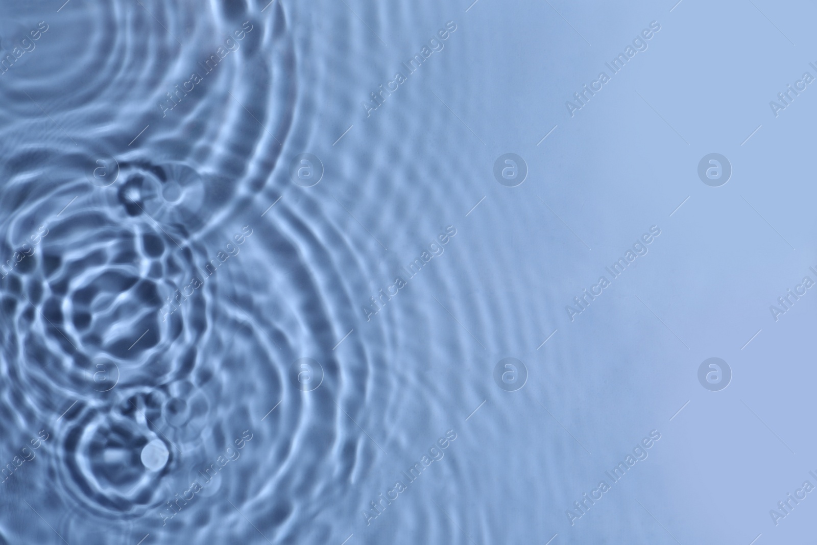 Photo of Closeup view of water with circles on blue background. Space for text