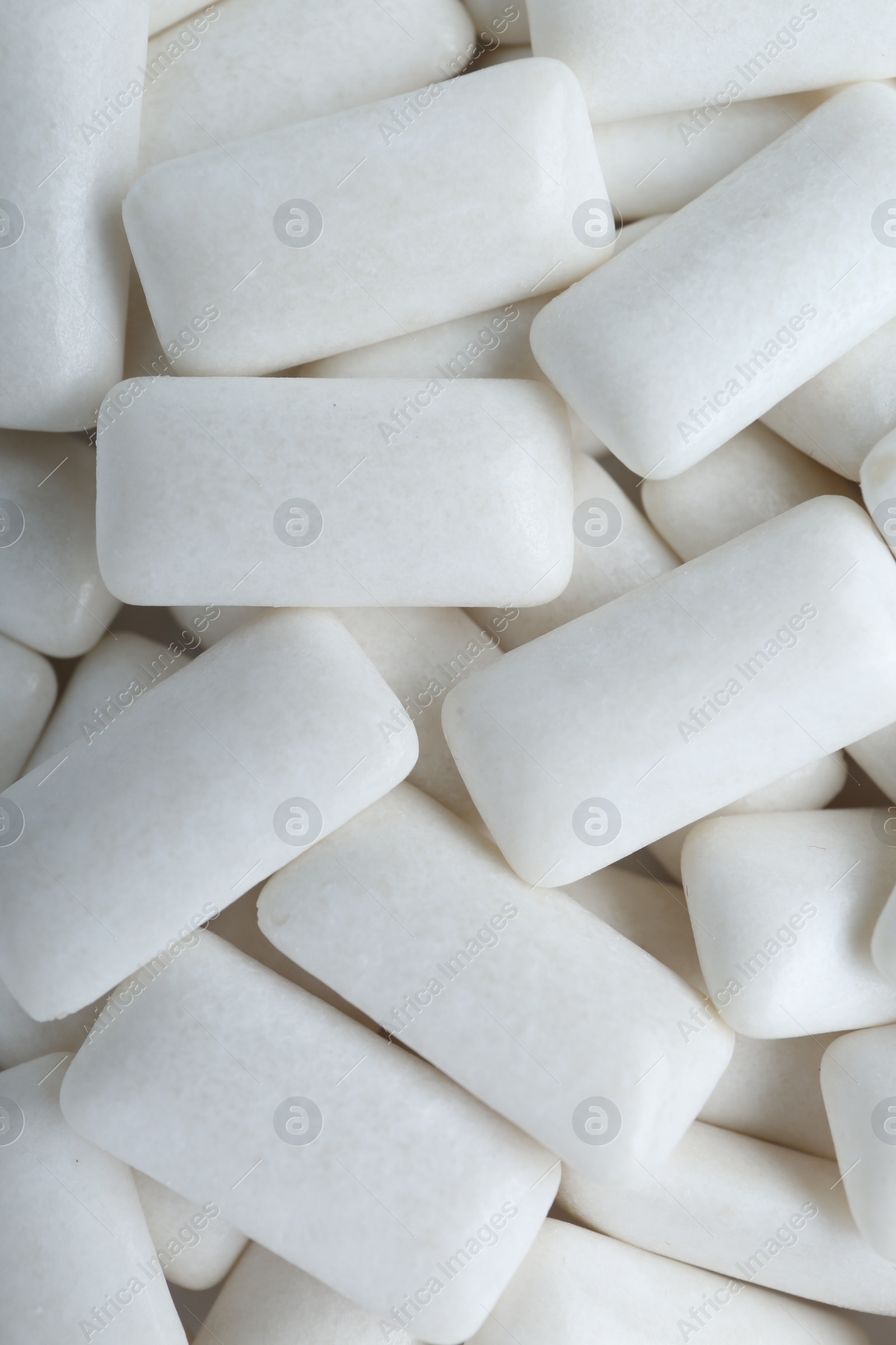 Photo of Tasty white chewing gums as background, top view