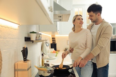 Photo of Happy couple preparing breakfast together in kitchen