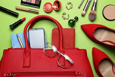 Photo of Flat lay composition with stylish woman's bag on light green background