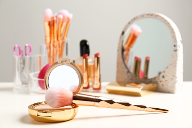 Photo of Compact powder and makeup brush on dressing table. Space for text