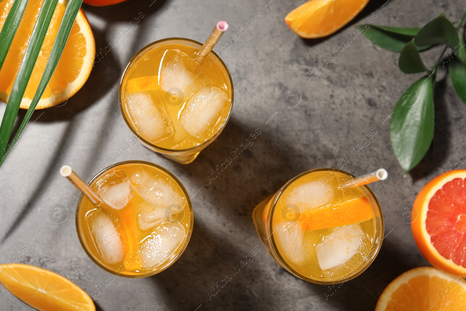 Photo of Delicious orange soda water on grey table, flat lay