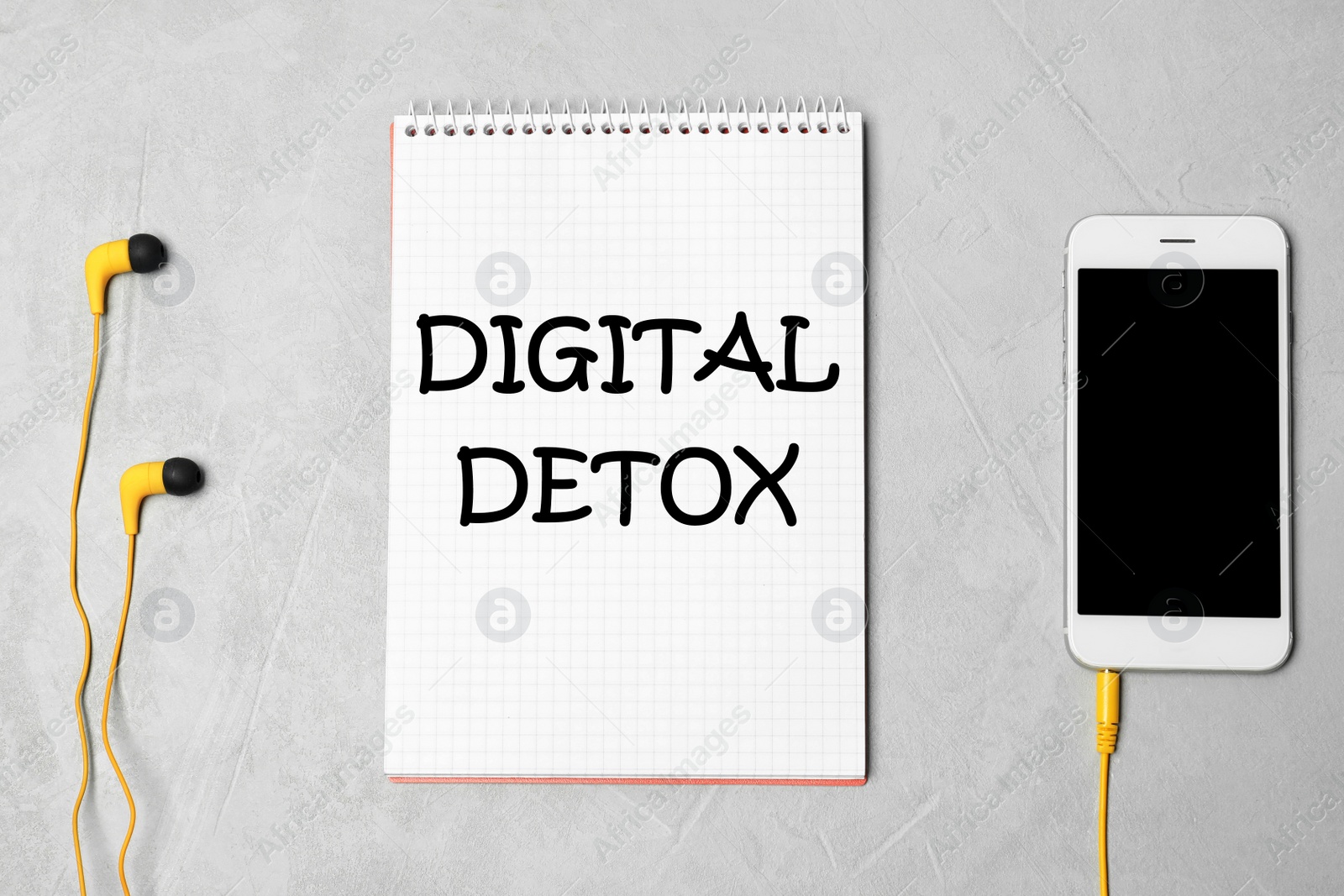 Image of Notebook with text Digital Detox, headphones and smartphone on grey background, flat lay